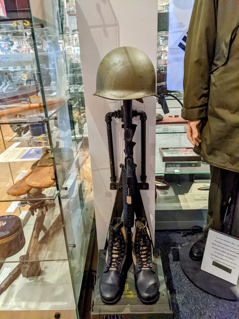 Traditional battlefield cross honoring fallen soldiers, displayed in a military museum for Memorial Day remembrance