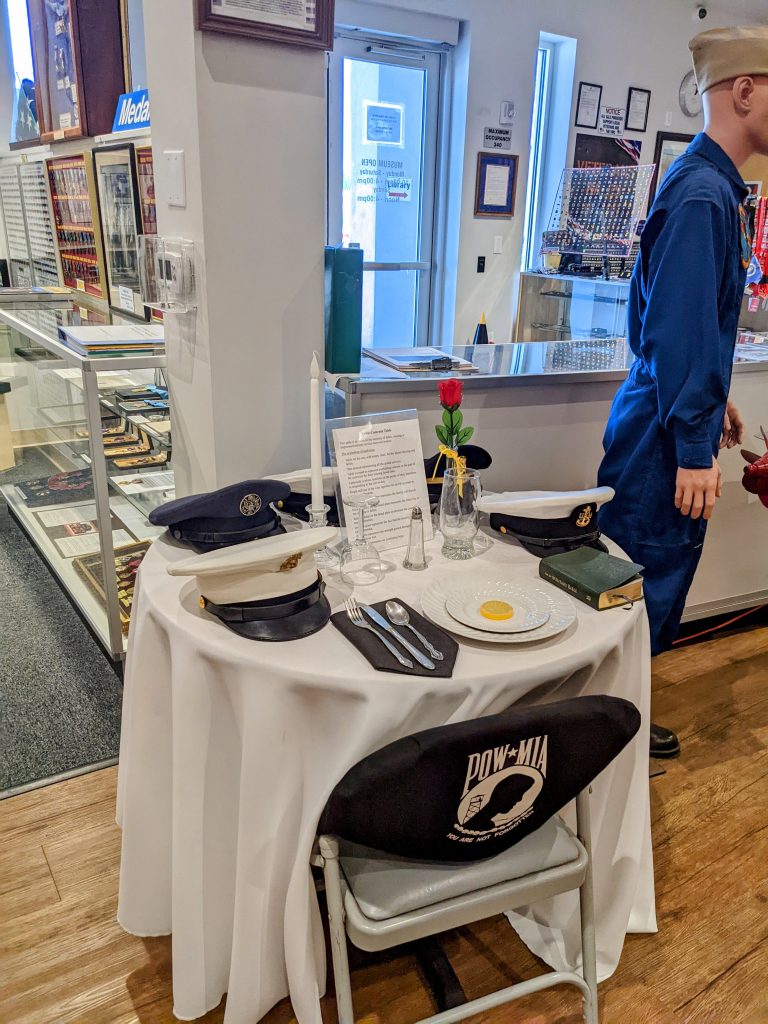 Fallen soldier remembrance table with single rose and empty place setting, honoring POW/MIA service members